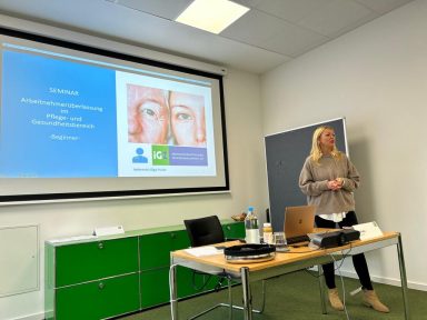 Seminar beim GVP mit Olga Punko von About Work GmbH Präsentation mit einer Frau vor einem Bildschirm und einem Tisch mit Laptop und Zubehör.