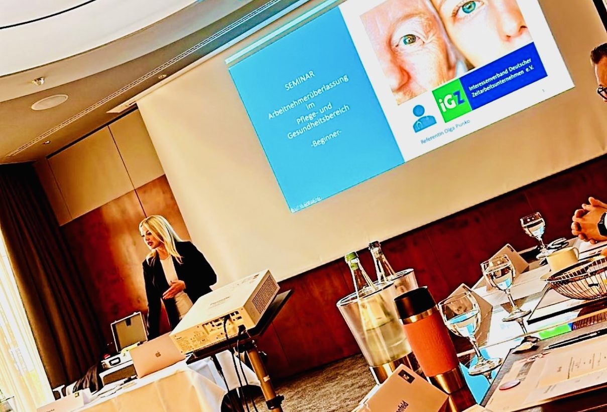 Olga Punko Dozentin About Work GmbH „Seminarleitung hält Vortrag über Arbeitnehmerüberlassung im Pflege- und Gesundheitsbereich – Schulungssituation mit Präsentation.“